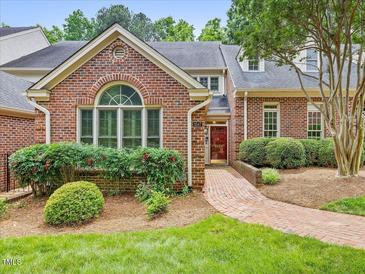 Charming brick home featuring a landscaped front yard and a welcoming brick pathway to the red front door at 3347 Ridgecrest Ct, Raleigh, NC 27607