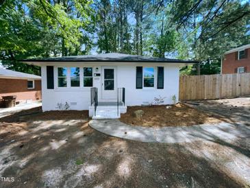 Charming white single-story home with black shutters and landscaped front yard at 600 Cecil St, Durham, NC 27707