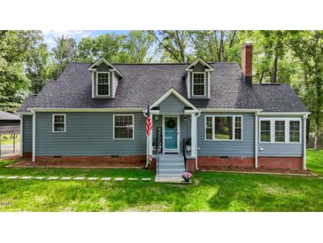 Charming home featuring dormer windows, a brick foundation, manicured lawn and inviting covered front entrance at 1052 Hughes Trl, Elon, NC 27244