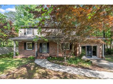 Charming brick home with a well-manicured lawn, mature trees and covered front porch at 1115 Chestnut Dr, Smithfield, NC 27577