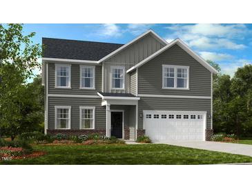 Charming two-story home with gray siding, a white two car garage, and a manicured front yard at 1128 Sun Springs Rd, Wake Forest, NC 27587