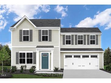 Charming two-story home featuring a two-car garage, neutral siding, and complemented by dark shutters at 1537 Ivy Meadow Ln, Zebulon, NC 27597