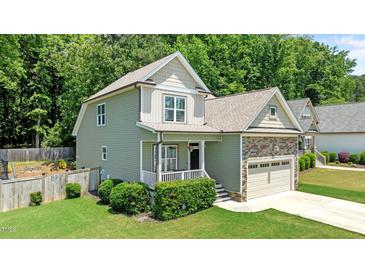 Charming two-story home with stone accents, a cozy front porch, and a lush green lawn at 240 Paddy Ln, Youngsville, NC 27596