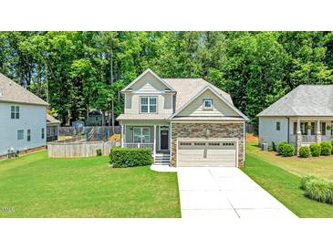Charming two-story home with stone accents, manicured lawn, and an attached two-car garage at 240 Paddy Ln, Youngsville, NC 27596