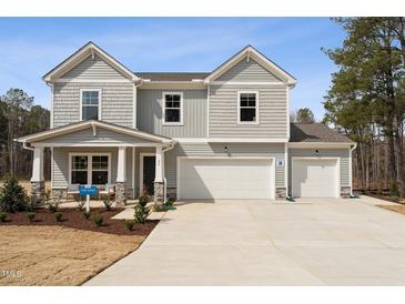 Charming two-story home featuring a spacious two-car garage and a welcoming front porch with stone accents at 27 Cribbs Ln, Middlesex, NC 27557