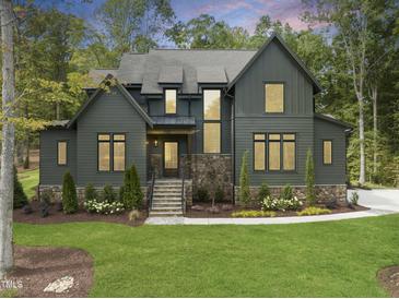 Stunning two-story home with a lush lawn, stone accents, and mature trees at 285 Mollie Meadow Dr, Zebulon, NC 27597