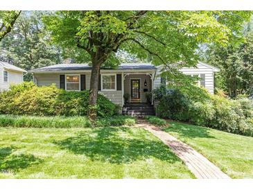 Charming single-story home with a beautiful lawn and lush landscaping at 2913 Anderson Dr, Raleigh, NC 27608