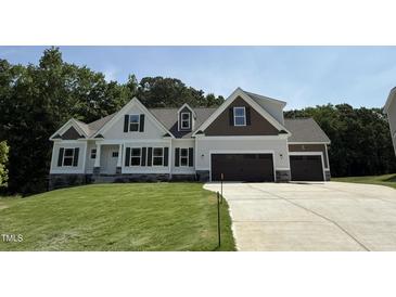 Beautiful new construction home featuring two-tone siding and a three-car garage at 322 Busterfield Ct, Benson, NC 27504