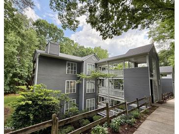 Three story exterior view of building with gray siding and upper level outdoor walkways at 4120 Sedgewood Dr # 106, Raleigh, NC 27612
