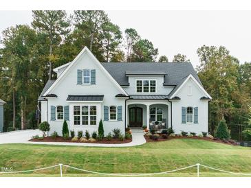 Charming light-blue home with manicured lawn, covered porch, and tasteful landscaping at 46 Addison Pond Ct, Zebulon, NC 27597