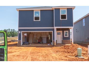 New two-story home featuring blue siding, unfinished yard, and an attached garage at 825 Ottawa Dr, Garner, NC 27529