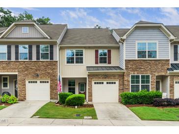 Townhome exterior features stone accents, attached garages, and well-maintained landscaping at 114 Constitution Dr, Durham, NC 27705