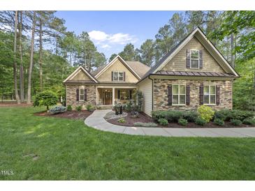 Charming home featuring a stone facade, manicured lawn, and inviting walkway at 1211 New Grissom Way, Wake Forest, NC 27587