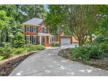 Charming brick home with mature trees and a well-manicured lawn, providing a welcoming curb appeal at 123 W Camden Forest Dr, Cary, NC 27518
