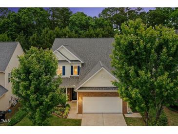 Charming two-story home with brick accents, white siding, manicured landscaping, and an attached two-car garage at 213 Florence Dr, Clayton, NC 27527