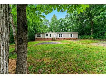 Charming single-story home with a well-maintained lawn, surrounded by lush greenery, and a traditional facade at 2832 Ladale Ln, Mebane, NC 27302