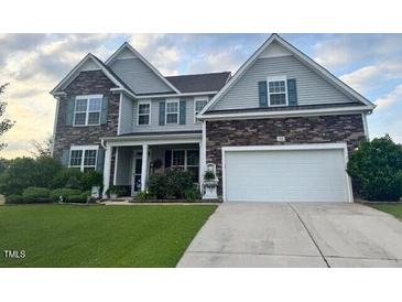 Charming two-story home with stone and siding, lush lawn, and a two-car garage at 30 Sunbury Ct, Zebulon, NC 27597
