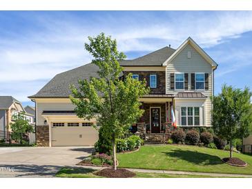 Charming home featuring a landscaped yard, stone accents, and a welcoming front porch with a two-car garage at 3128 Mountain Hill Dr, Wake Forest, NC 27587