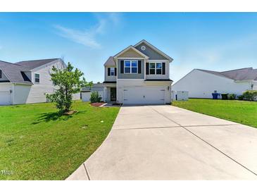 Charming two-story home with a well-manicured lawn and a spacious driveway on a sunny day at 350 Pillow Ln, Burlington, NC 27217