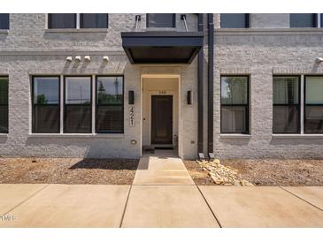 Modern townhome front door with a black awning and light brick facade at 421 Wait Ave # 100, Wake Forest, NC 27587