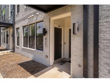 Modern townhome featuring a brick facade, covered entrance, and visible unit number at 421 Wait Ave # 100, Wake Forest, NC 27587