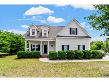 Inviting home showcasing dormer windows and covered front porch at 509 Spruce Meadows Ln, Willow Springs, NC 27592