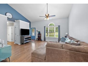 Bright living room featuring a large window, ceiling fan, and a comfortable, oversized sectional sofa at 687 W Watson Rd, Benson, NC 27504