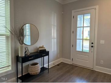 Bright entryway with a decorative table, mirror, and woven basket, creating a welcoming atmosphere at 1006 Starkville St, Durham, NC 27713