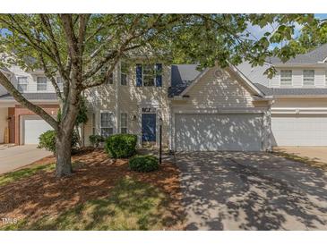 Charming home featuring blue shutters, a well-kept lawn, and an attached two-car garage at 1031 Lake Moraine Pl, Raleigh, NC 27607