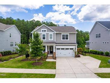 Charming two-story home featuring a manicured lawn, a two-car garage, and a welcoming front porch at 113 Hidden Bluff Dr, Chapel Hill, NC 27517