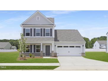 Charming two-story home with gray siding, a two-car garage, and a well-manicured lawn at 142 Benson Village Dr # 82, Benson, NC 27504