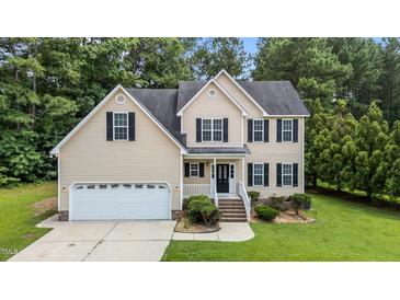 Inviting two-story home with a manicured lawn, black shutters, and a two-car attached garage at 185 Keller Dr, Clayton, NC 27520