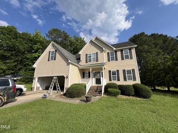 Charming two-story home with black shutters, manicured lawn, and attached garage at 185 Keller Dr, Clayton, NC 27520