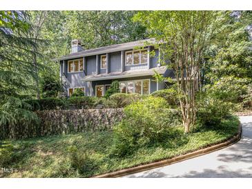 Two-story home with stone retaining wall and lush surrounding trees at 203 Old Forest Creek Dr, Chapel Hill, NC 27514
