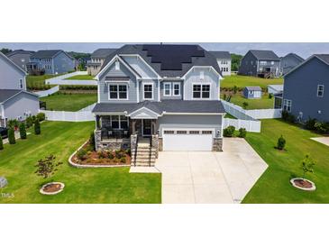 Beautiful two-story home with solar panels, manicured lawn, and a welcoming stone porch at 272 High Woods Rdg, Chapel Hill, NC 27517