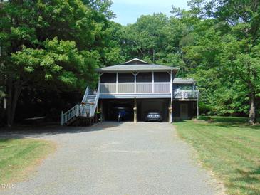 Two-story home featuring dual carports and a screened porch with a staircase entrance at 4144 Fairport Rd, Kittrell, NC 27544