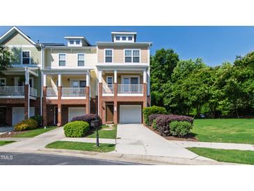 Charming townhome with a brick facade, private balcony, and well-manicured lawn at 717 Samuel Cary Dr, Cary, NC 27511