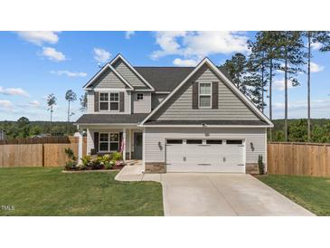 Charming two-story home with a well-manicured lawn and attached two-car garage at 784 Cypress Rd, Cameron, NC 28326