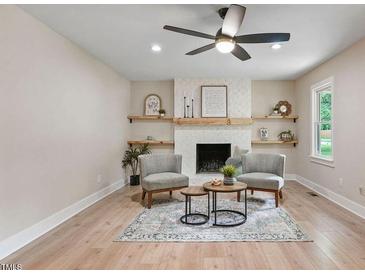 Inviting living room features a fireplace with decorative mantle and floating shelves at 847 E Maple Ln, Fuquay Varina, NC 27526