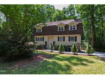 Charming two-story home with a well-manicured lawn and mature trees providing shade at 1005 Temple St, Raleigh, NC 27609
