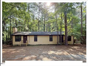 Cozy single-story home with a welcoming front porch nestled among the trees at 125 Forsyth Dr, Chapel Hill, NC 27517