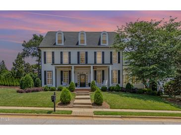 Stately two-story home with black shutters, covered porch, manicured lawn, and inviting curb appeal at 12500 Richmond Run Dr, Raleigh, NC 27614