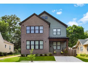 Charming two-story home with a brick and siding exterior, landscaped yard, and a welcoming front porch at 1405 Watts St, Durham, NC 27701