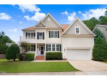 Charming two-story home with beautiful landscaping, a front porch, and an attached two-car garage at 1420 Lagerfeld Way, Wake Forest, NC 27587