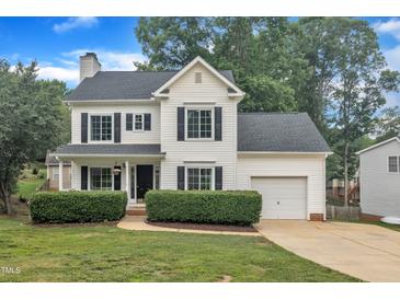 Charming two-story home with a manicured lawn, black shutters, and an attached garage at 201 Crossfire Rd, Holly Springs, NC 27540