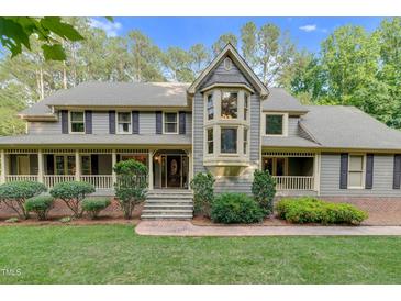 Charming two-story home with a bay window, landscaped yard, and covered porch with a stone walkway to the front door at 201 Village Dr, Knightdale, NC 27545