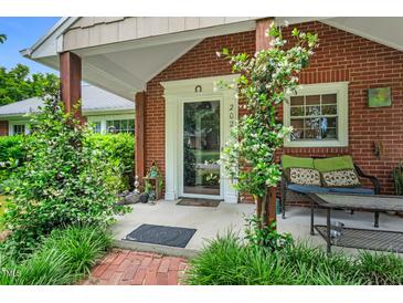 Inviting front porch with brick accents, cozy seating, and lush landscaping at 202 Hilltop Ave, Garner, NC 27529