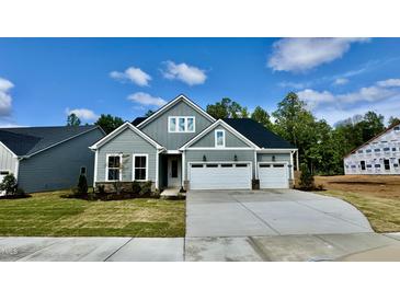 Charming two-story home featuring a three-car garage and manicured front lawn at 2313 Abbeyhill Dr # 3, Raleigh, NC 27610