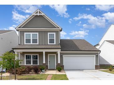 Attractive two-story home with an attached garage, covered porch and well-maintained landscaping at 34 Tanglewood Pl, Angier, NC 27501