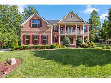 Traditional brick home featuring red shutters, a spacious front lawn, and an inviting two-story entrance at 3404 Mount Pisgah Way, Cary, NC 27519